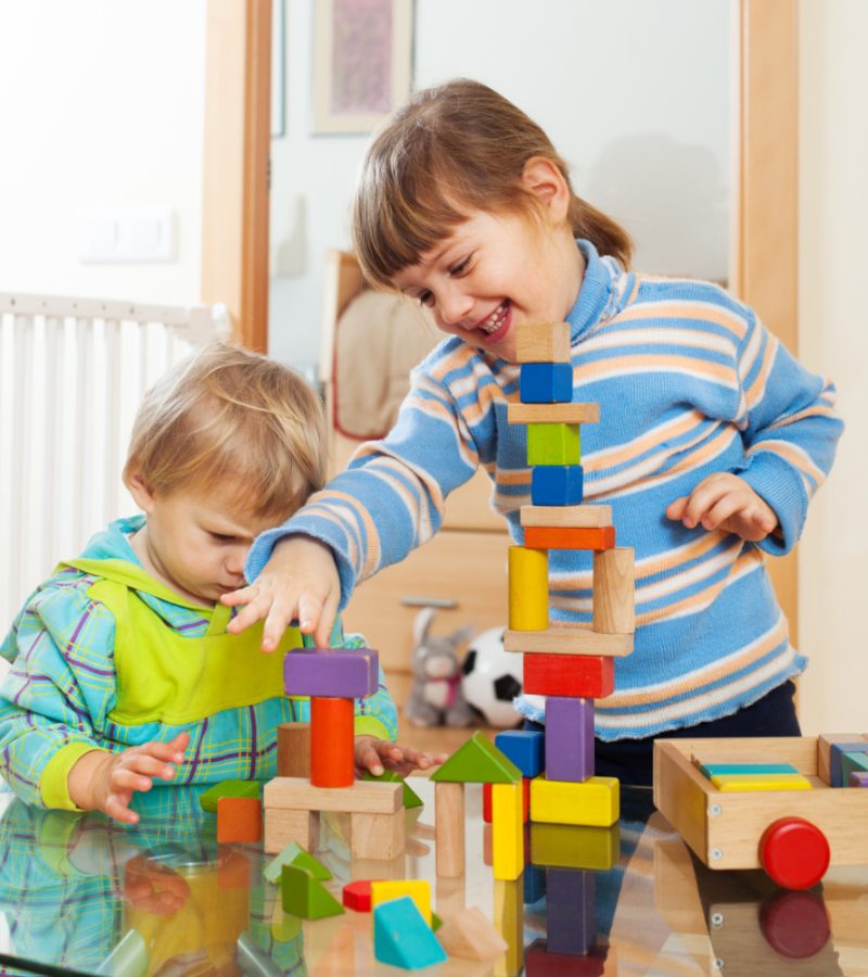 siblings-together-playing-with-toys